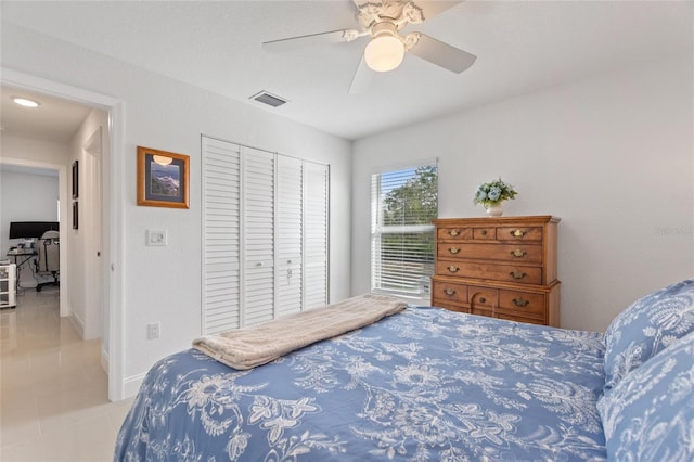 bedroom featuring light tile patterned flooring, ceiling fan, and a closet