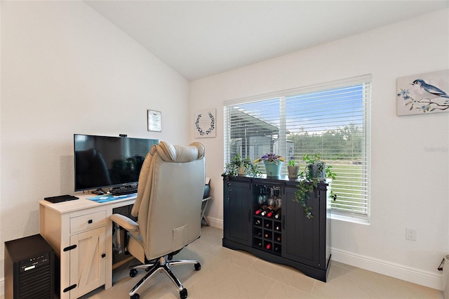 office space featuring lofted ceiling and light tile patterned floors