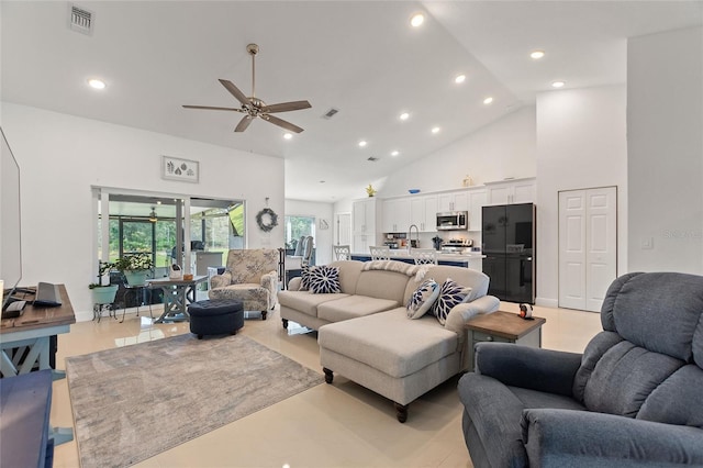 living room featuring ceiling fan, sink, and high vaulted ceiling