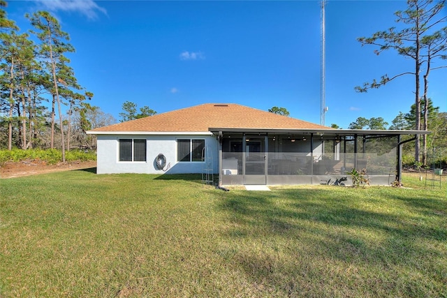 rear view of property featuring a sunroom and a lawn