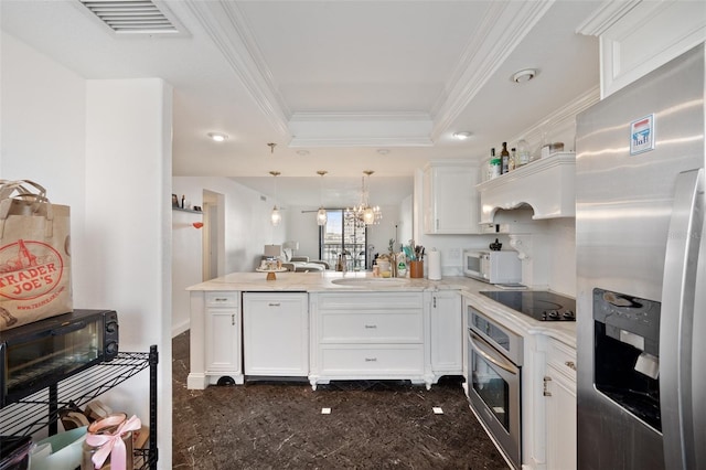 kitchen with stainless steel appliances, a raised ceiling, white cabinetry, and kitchen peninsula