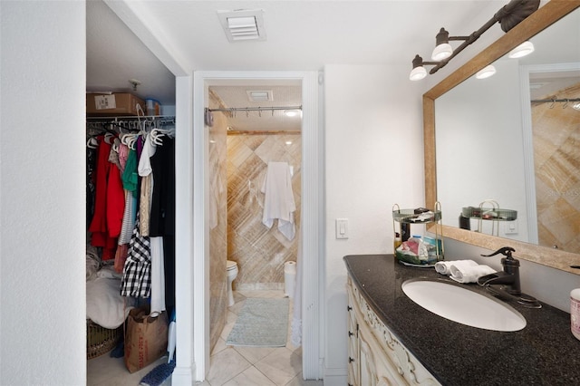 bathroom featuring vanity, tiled shower, and toilet