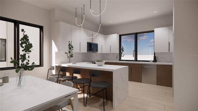 kitchen featuring white cabinetry, dishwasher, and a breakfast bar area