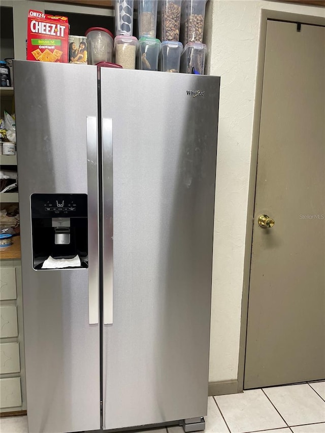 kitchen with stainless steel refrigerator with ice dispenser and light tile patterned flooring