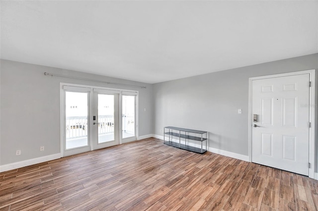 unfurnished room with wood-type flooring and french doors