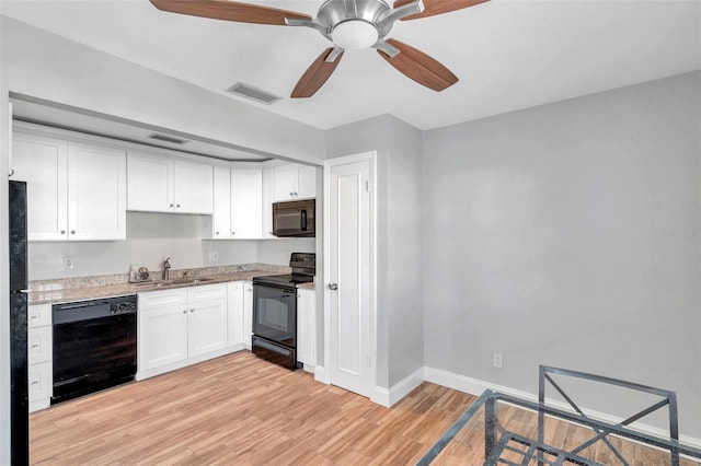 kitchen featuring sink, white cabinetry, light stone counters, light hardwood / wood-style flooring, and black appliances