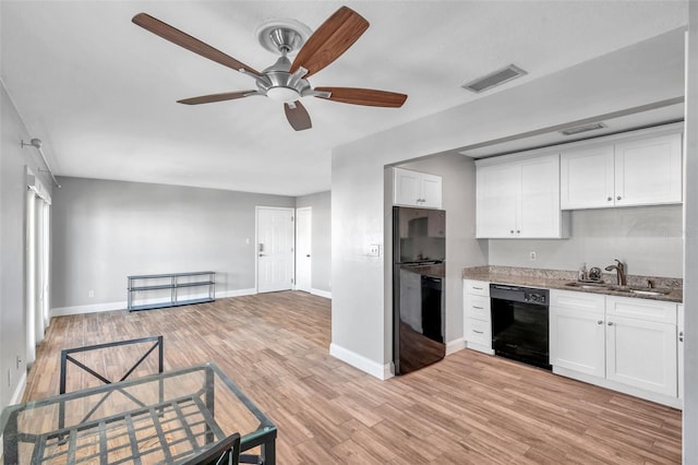 kitchen with sink, light hardwood / wood-style flooring, white cabinetry, black appliances, and stone countertops