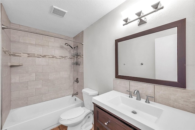 full bathroom featuring tiled shower / bath combo, vanity, tasteful backsplash, a textured ceiling, and toilet