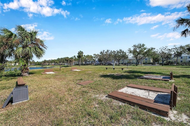 surrounding community featuring a water view and a lawn