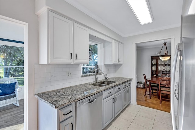 kitchen with stainless steel appliances, white cabinetry, sink, and crown molding