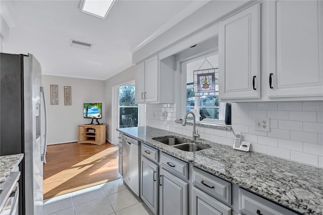 kitchen with crown molding, stainless steel appliances, sink, and white cabinets