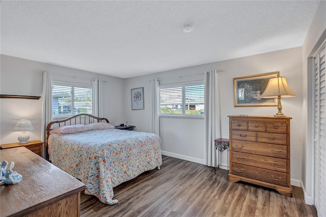 bedroom with dark wood-type flooring and a textured ceiling