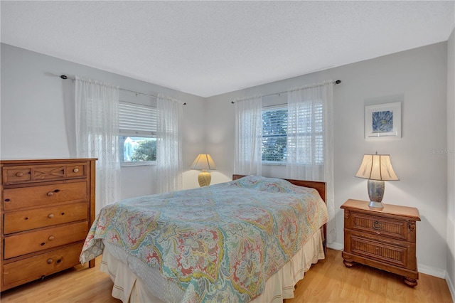 bedroom featuring a textured ceiling and light hardwood / wood-style floors