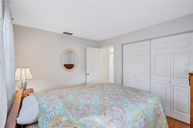 bedroom with light wood-type flooring and a closet