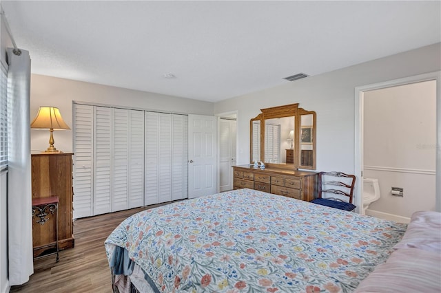 bedroom with wood-type flooring, a closet, a textured ceiling, and ensuite bathroom