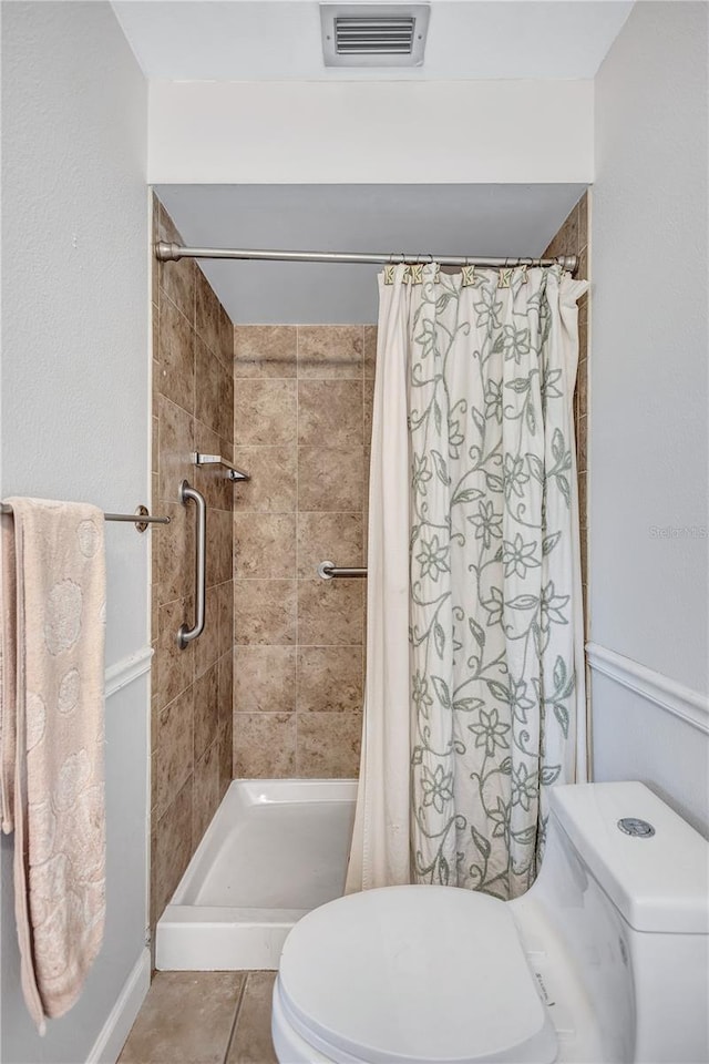 bathroom with tile patterned flooring, toilet, and a shower with curtain