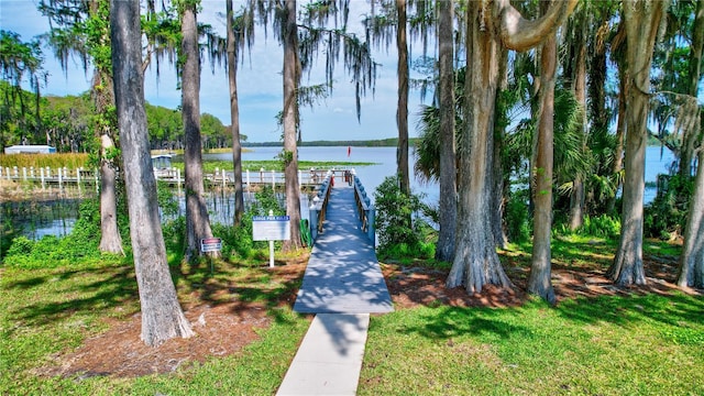 view of dock featuring a water view and a lawn