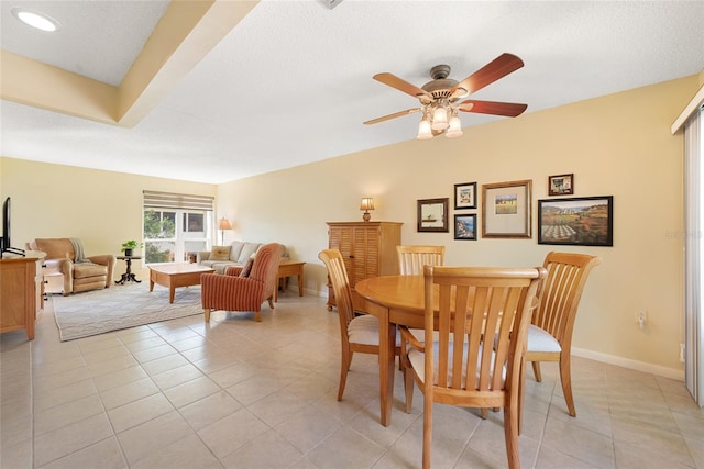 tiled dining area featuring ceiling fan, lofted ceiling, and a textured ceiling