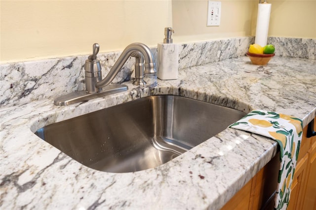 interior details with sink and light stone countertops