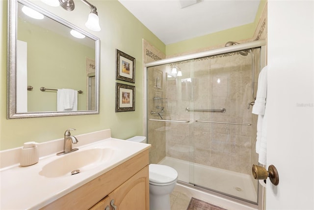 bathroom with vanity, tile patterned flooring, a shower with door, and toilet