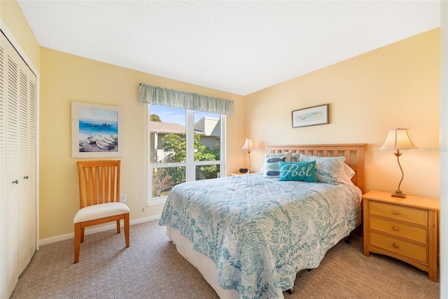 bedroom with light carpet, a textured ceiling, and a closet