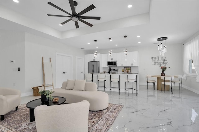 living room featuring a tray ceiling and ceiling fan