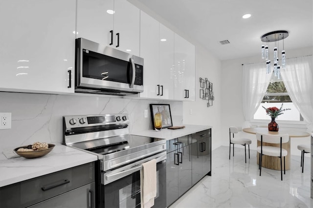 kitchen with white cabinetry, tasteful backsplash, decorative light fixtures, stainless steel appliances, and light stone countertops