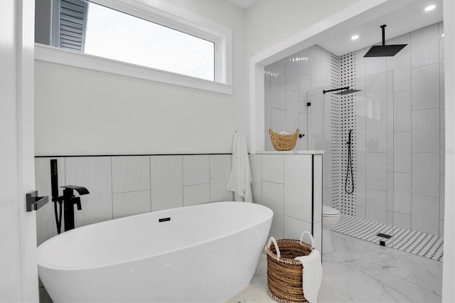 bathroom with tile walls, toilet, and separate shower and tub