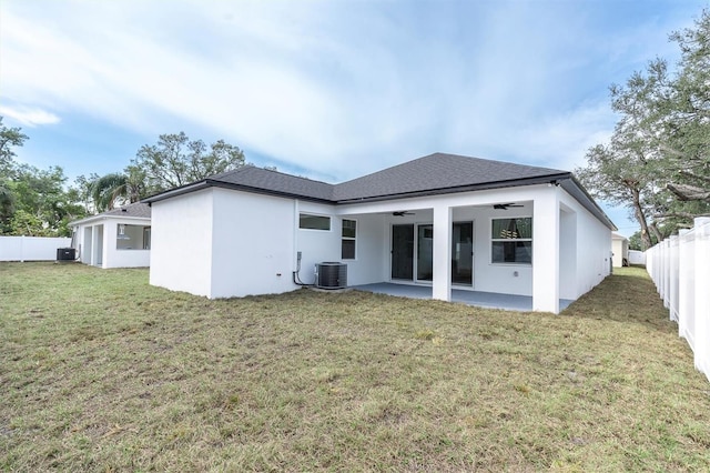 rear view of house with central AC, ceiling fan, a yard, and a patio