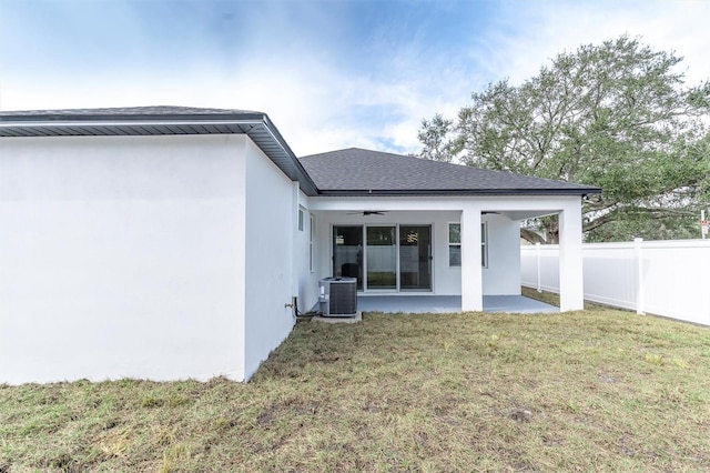 back of house with cooling unit, ceiling fan, a yard, and a patio