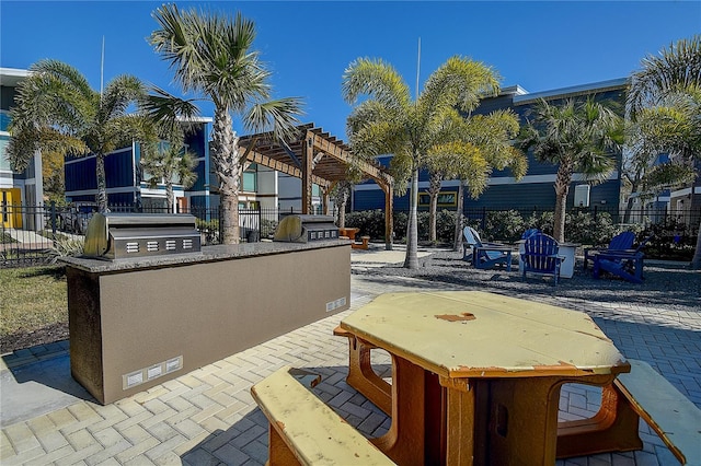 view of patio with area for grilling, a pergola, and exterior kitchen