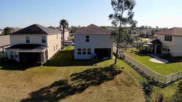 rear view of property featuring cooling unit and a lawn