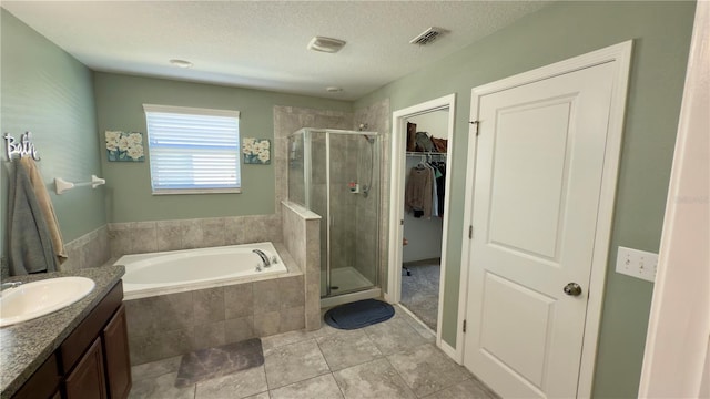 bathroom with vanity, tile patterned floors, shower with separate bathtub, and a textured ceiling