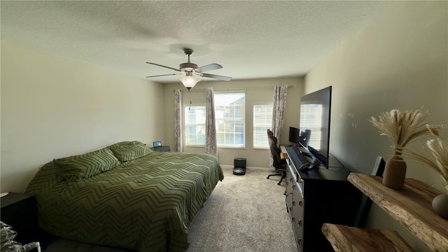 carpeted bedroom featuring ceiling fan and a textured ceiling