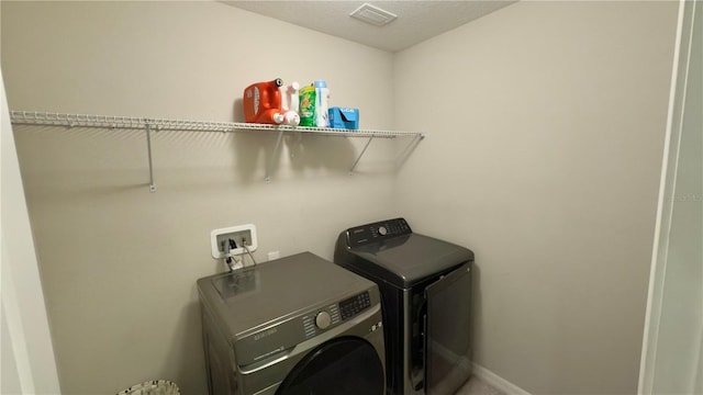 clothes washing area featuring separate washer and dryer