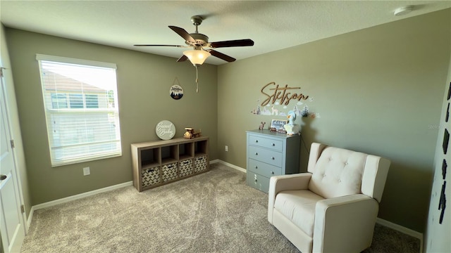 living area featuring ceiling fan and light colored carpet