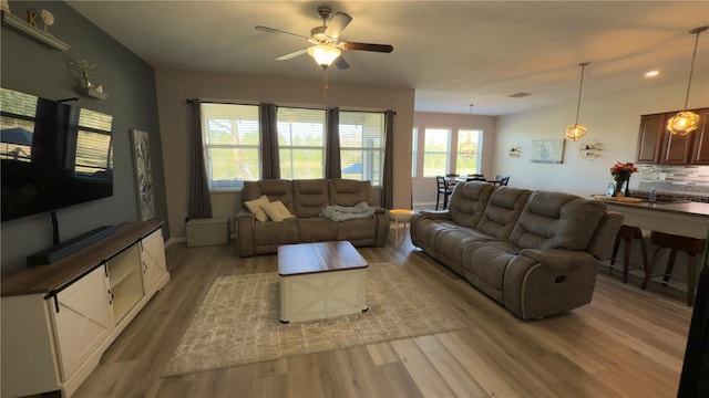 living room featuring light hardwood / wood-style flooring and ceiling fan