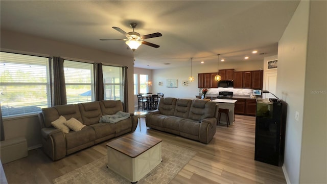 living room featuring ceiling fan and light hardwood / wood-style flooring