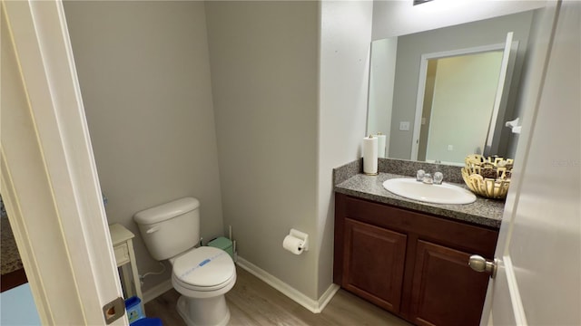 bathroom featuring vanity, hardwood / wood-style floors, and toilet