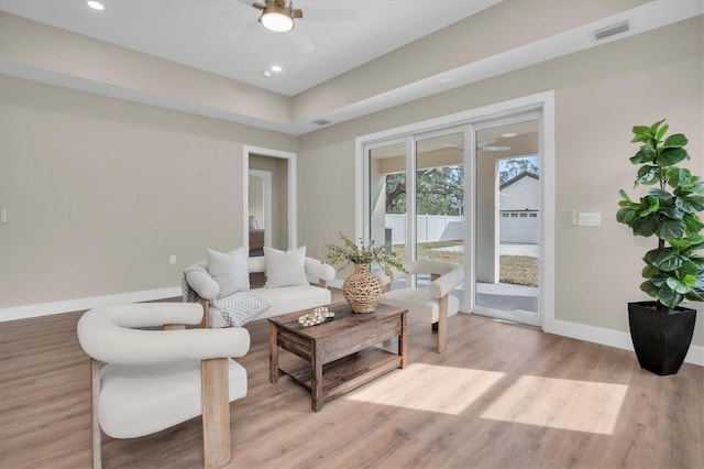 living room with ceiling fan and light hardwood / wood-style flooring