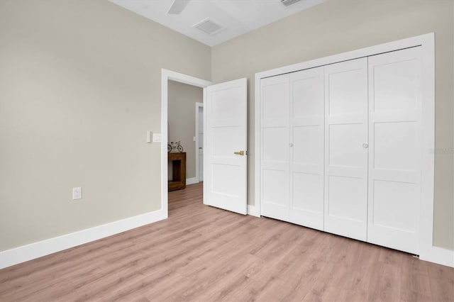 unfurnished bedroom featuring ceiling fan, light hardwood / wood-style floors, and a closet