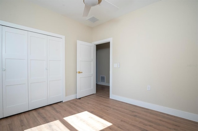 unfurnished bedroom featuring ceiling fan, light wood-type flooring, and a closet