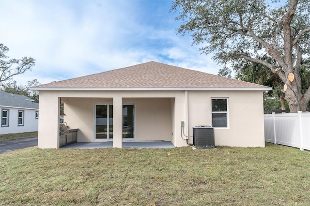 back of house with central AC unit, a patio, and a lawn