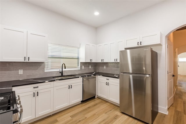 kitchen featuring light wood-type flooring, stainless steel appliances, sink, and white cabinets