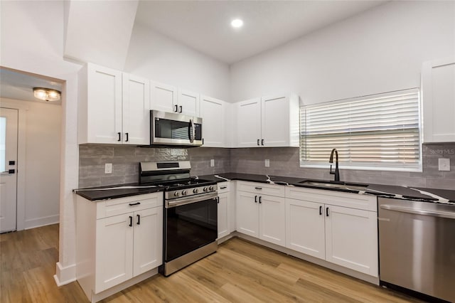 kitchen with stainless steel appliances, white cabinetry, and sink