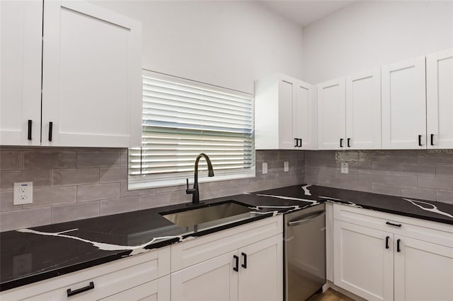 kitchen featuring tasteful backsplash, stainless steel dishwasher, sink, and white cabinets