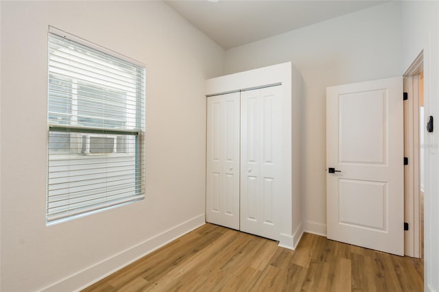 unfurnished bedroom with light hardwood / wood-style floors and a closet