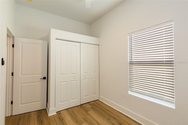 unfurnished bedroom with light hardwood / wood-style flooring and a closet