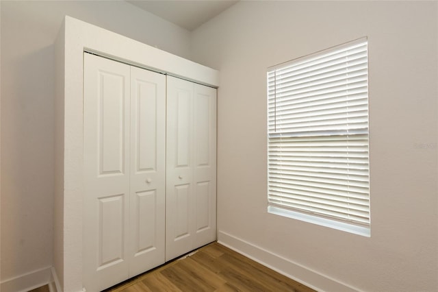 unfurnished bedroom featuring wood-type flooring and a closet