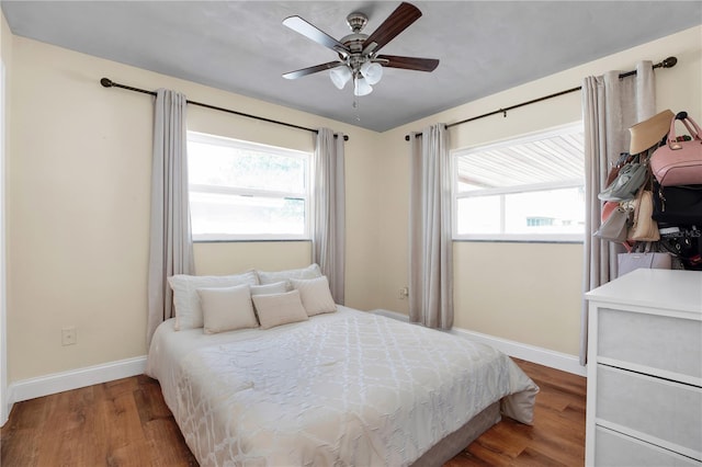 bedroom featuring multiple windows, hardwood / wood-style floors, and ceiling fan